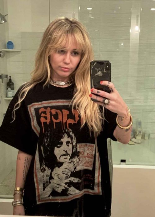 Miley Cyrus tomándose una fotografía frente al espejo de su nuevo look de Hannah Montana