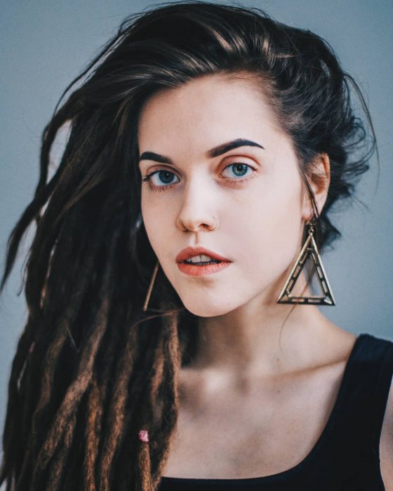 Chica de cabello castaño y ojos azules con rastas