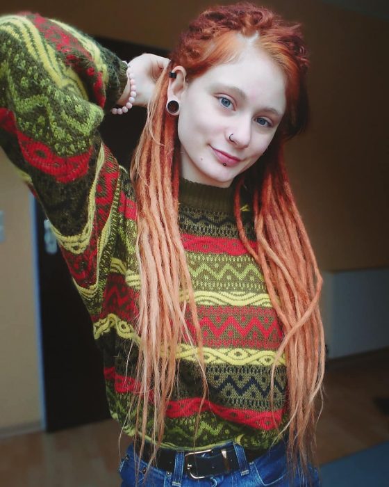 Chica pelirroja con rastas y suéter