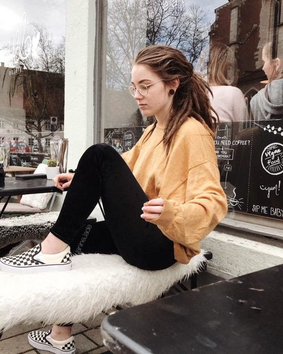 Chica con rastas sentada en un café