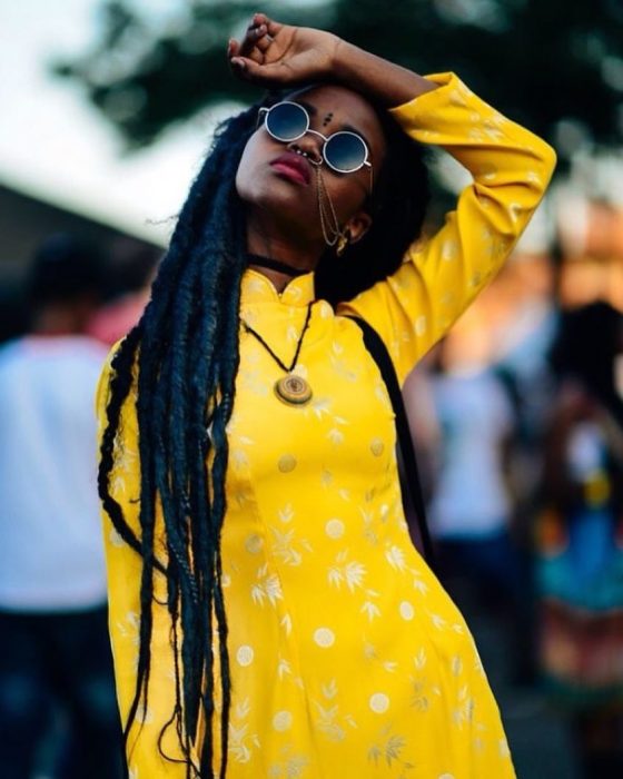 Chica morena con rastas y vestido amarillo