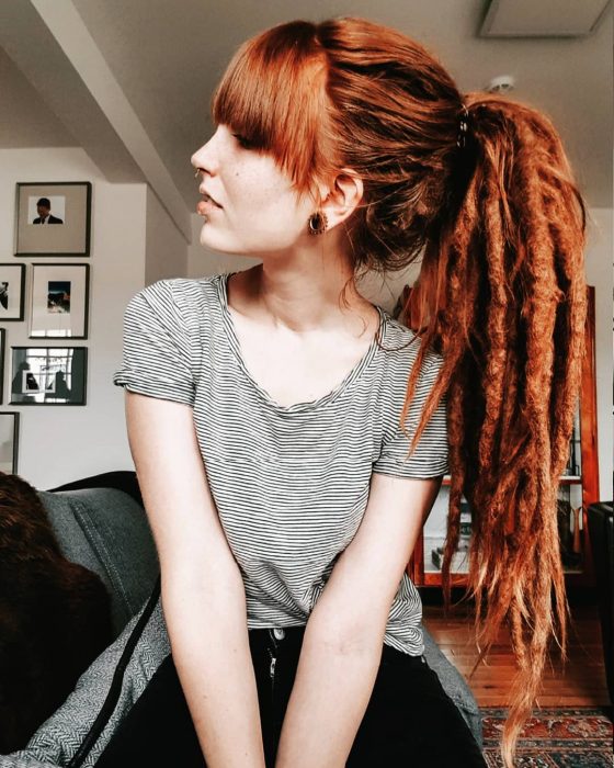 Chica pelirroja con rastas y una coleta de caballo