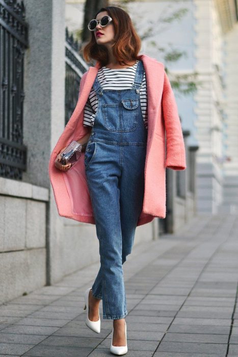 Chica con overol de mezvlilla, playera a rayas, saco rosa y lentes de sol