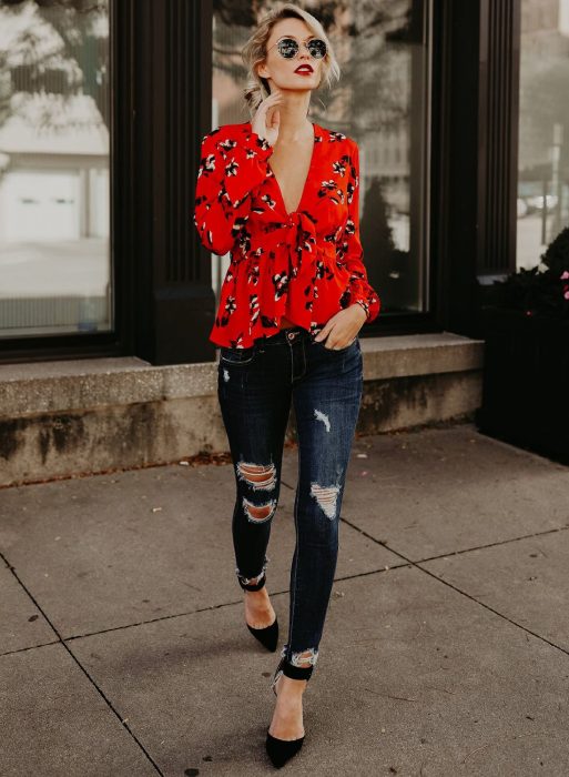 Chica con blusa roja, jeans desgastados y tacones