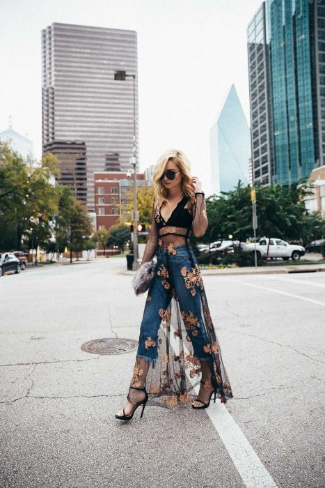 Chica rubia con jeans y tacones usando un kimono de encaje