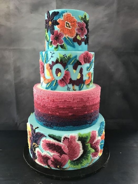 Pastel de cuatro pisos, con fondo en betún color aqua y decorado con efecto bordado en flores y aves