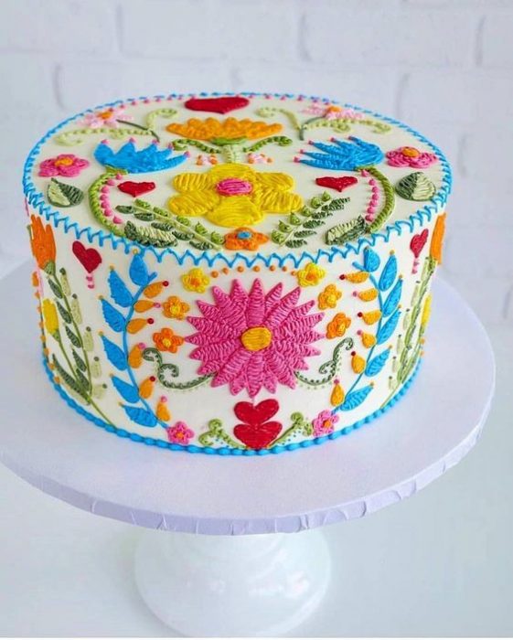 Pastel clásico decorado con efecto bordado con flores en tonos rosa, naranja, azul, amarillo, rojo y rosa