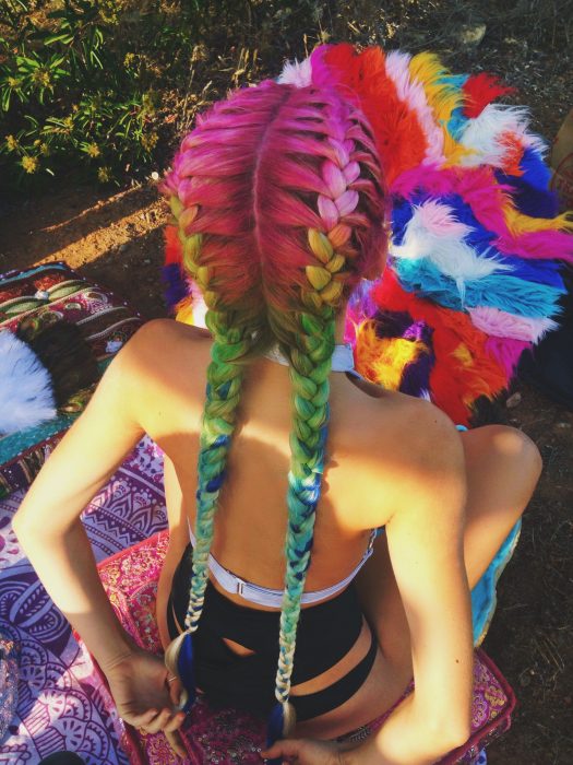 Chica con cabello de colores peinado en dos trenzas estilo boxeadora