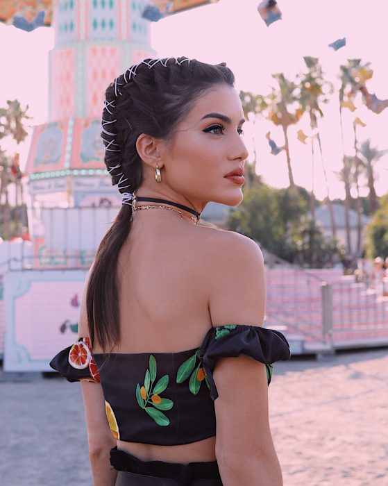 Chica mirando al horizonte peinada con trenzas y adornos de ligas