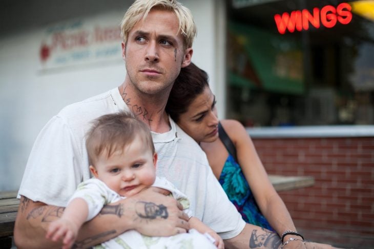 Eva Medes y Ryan Goslin en escena de El lugar donde todo termina - Hombre rubio tatuado con mujer y bebé