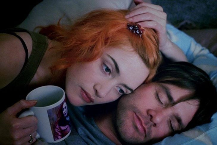 Kate Winslet y Jim Carrey en Eterno resplandor de una mente sin recuerdos - chica pelirroja con taza recostada junto a hombre dormido