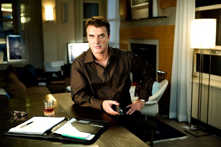 El actor Chris Noth sentado en un escritorio en la película Sex and the City