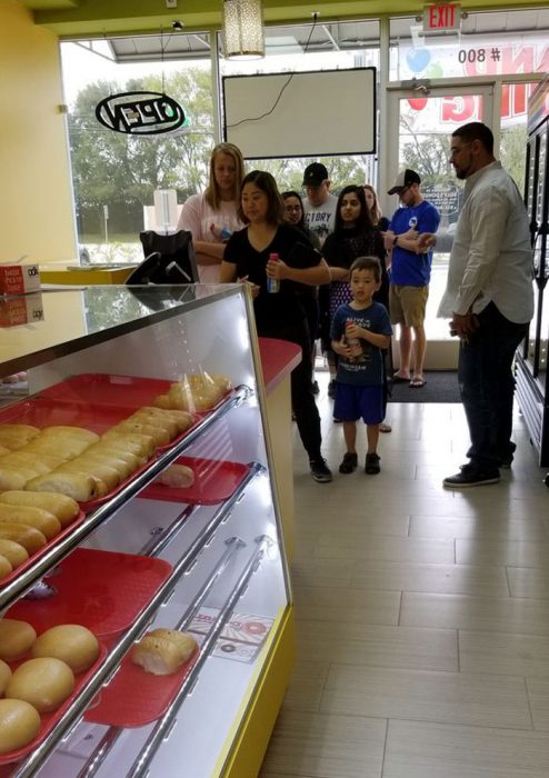 Personas haciendo fila para comer donas 