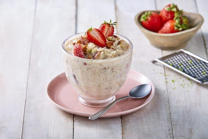 Arroz con leche decorado con fresas fileteadas y nuez