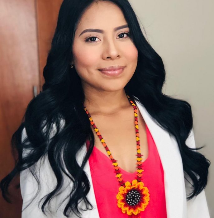 Chica indígena sonriendo con collar típico