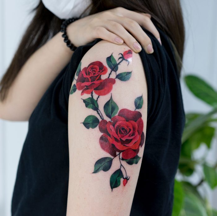 Tatuaje colorido de rosas rojas en el brazo