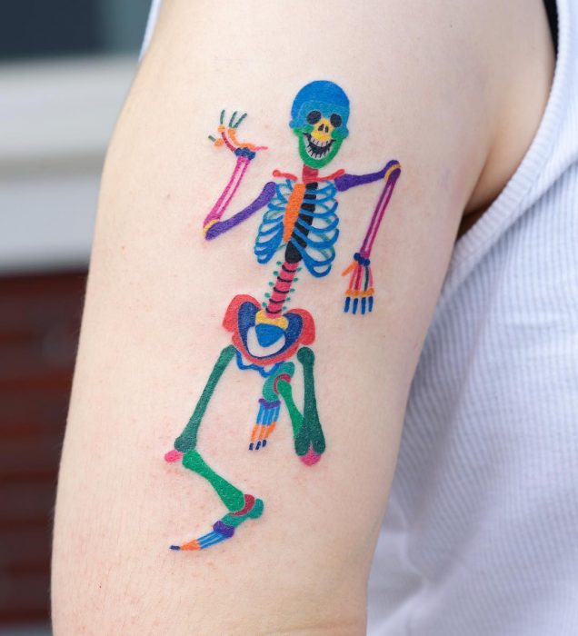 Tatuaje colorido de calavera en el brazo hecho por tatuadora coreana Zihnee