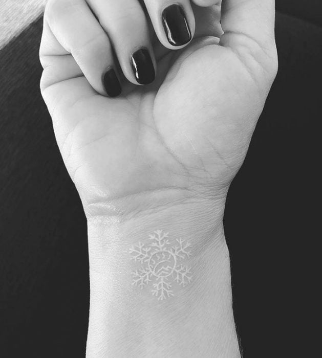 Diseño de tatuaje de tinta blanca que es un copo de nieve