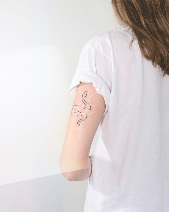 Diseño de tatuaje de serpientes entrelazadas en tinta blanca y negra 