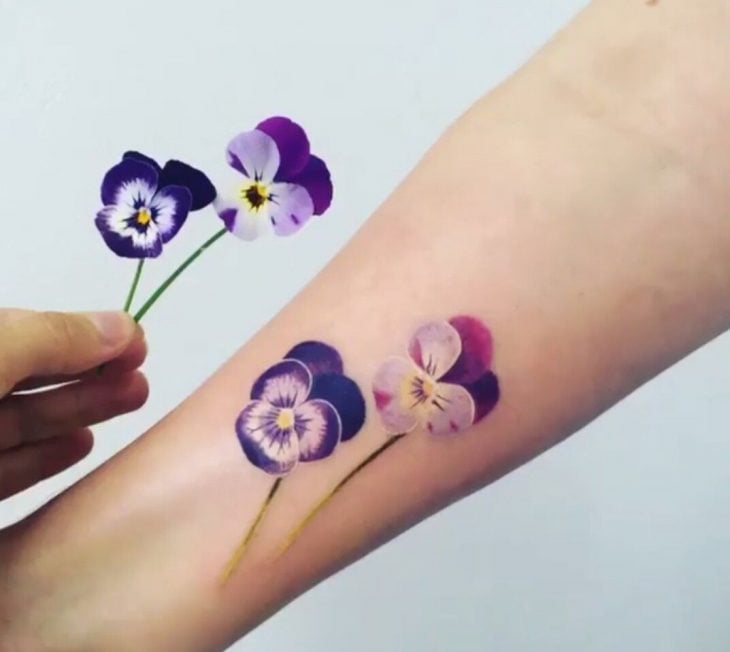 Mujer con tatuaje de flor en el brazo