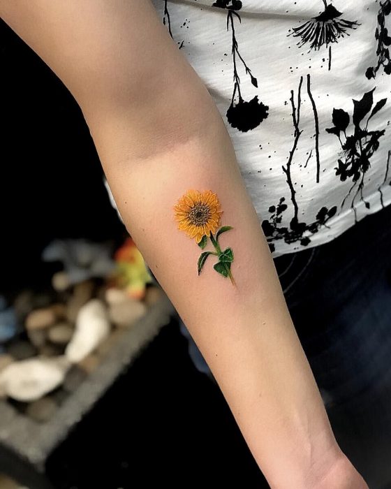 Mujer con tatuaje de flor en el brazo