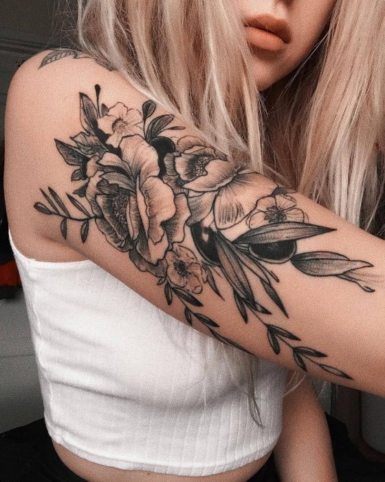 Mujer con tatuaje de flor en el brazo