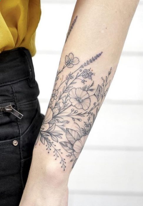 Mujer con tatuaje de flor en el brazo