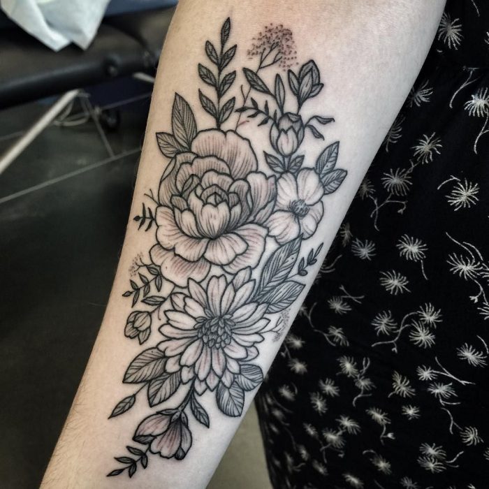 Mujer con tatuaje de flor en el brazo