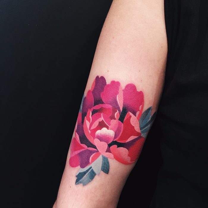 Mujer con tatuaje de flor en el brazo