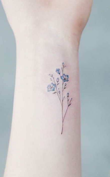 Mujer con tatuaje de flor en el brazo