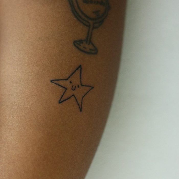 Tatuaje de una estrella con líneas negras hecho por la tatuadora Helen Fernandes