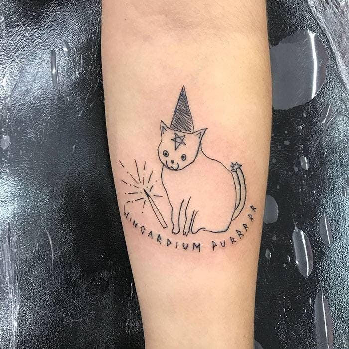 Tatuaje de trazo sencillo de un gato brujo inspirado en Harry Potter hecho por la tatuadora Helen Fernandes