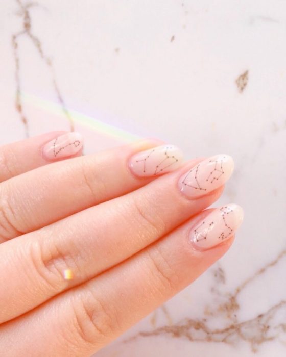 Manicura femenina y minimalista de constelaciones con uñas rosa pálido