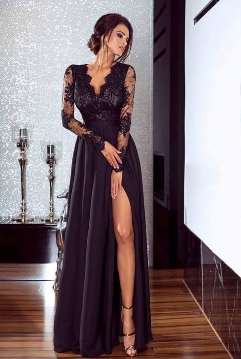 Chica modelando un vestido negro con abertura en la pierna y detalles de encaje en los brazos