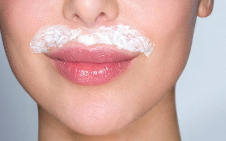 Mujer mostrando sus labios y la decoloración que hace a su bigote femenino