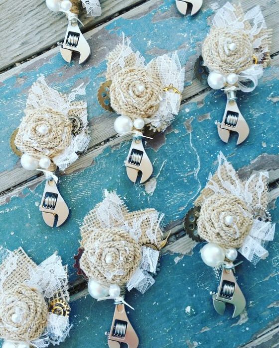 Llaves de presión decoradas con flores blancas como recordatorios para una boda estilo biker 