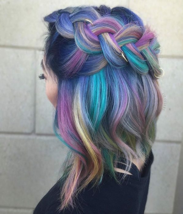 Tendencia de cabello, tinte oil slick que parece aceite derramado en el suelo, chica con peinado de trenza ancha con argollas, cabellera de colores lila, rosa, verde aqua y amarillo