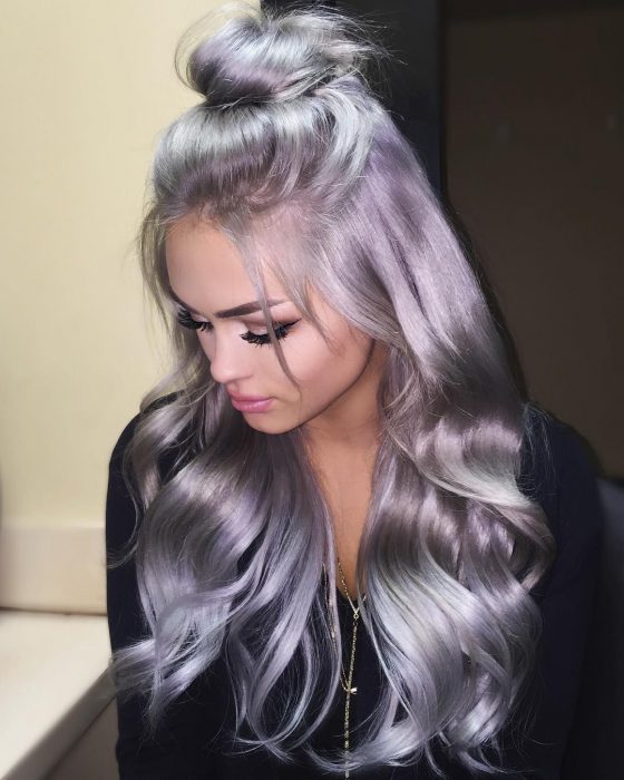 Chica con el cabello brilloso color gris lavanda o lavender gray, largo y ondulado con bun alto