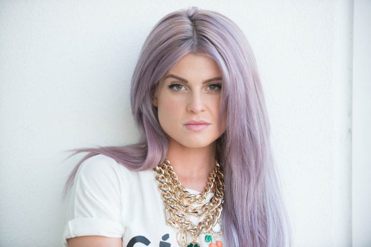 Cantante y presentadora Kelly Osbourne, chica de ojos verde con cabello largo y lacio, color gris lavanda o lavender gray en tonalidad rosa, con collar de cadena dorado