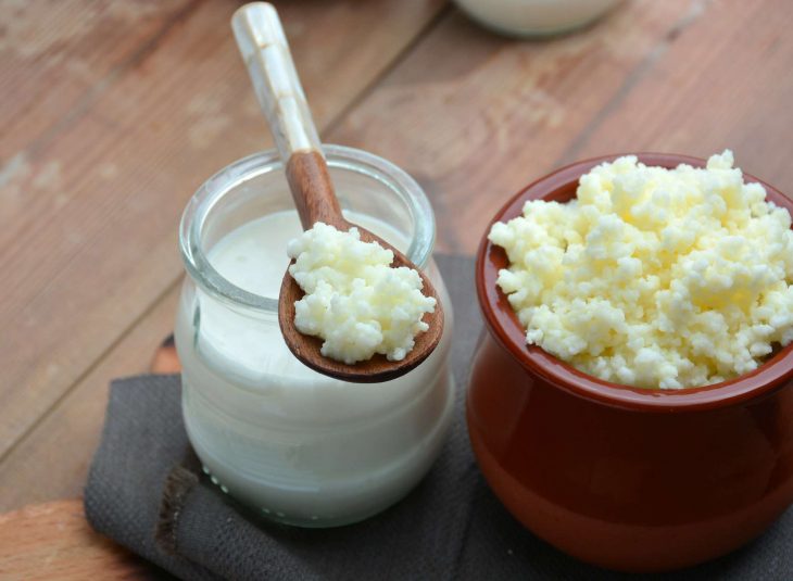 Tazas de leches y yogurt en mesa de madera