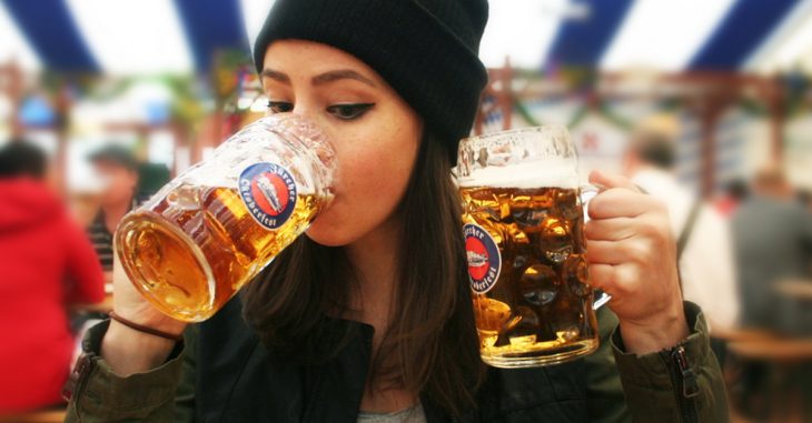 Chica bebiendo tarros de cerveza frente a una cámara 