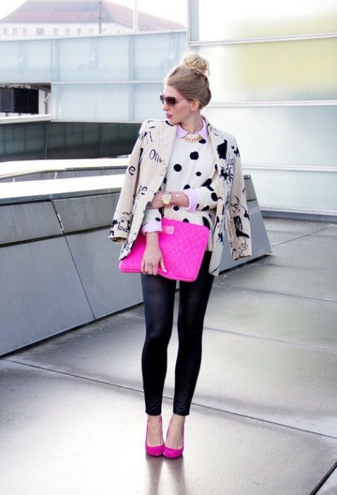 Chica modelando un suéter de lunares, una chamarra de piel, leggins negros y un bolso rosa