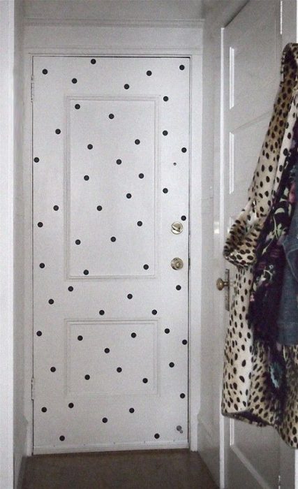 White door of a wardrobe decorated with black dots 