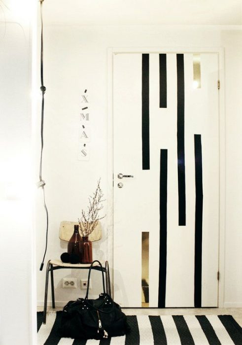 Door of a room decorated with black lines that combine with the carpet in the room 