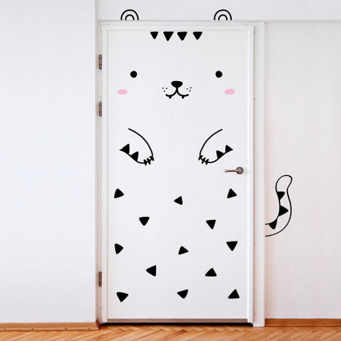 Puerta de una habitación decorada con un vinil de gatito 