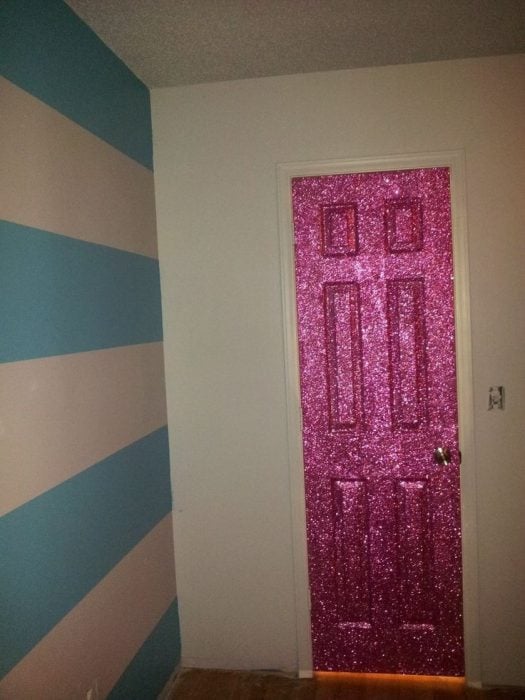 Puerta de una habitación pintada con pintura de glitter de color rosa 