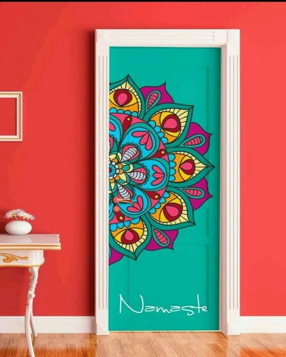 Puerta de una habitación decorada con un mandala de colores y abajo la frase namaste 
