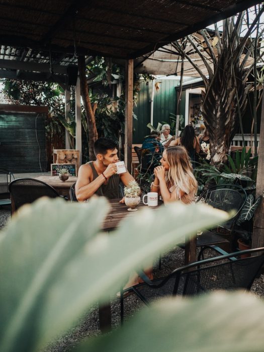 Pareja d enovios bebiendo café en un restaurante sobre la playa 