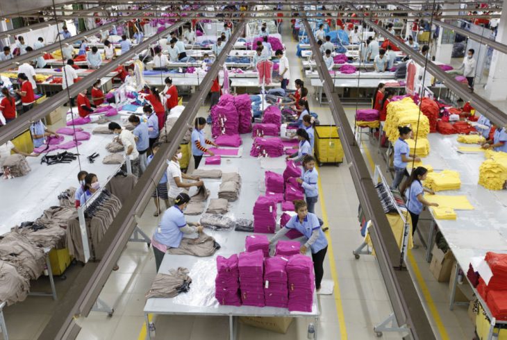 Fabrica textil, mujeres trabajando en maquinas de coser industriales dentro de una fabrica de ropa, escena del documental The True Cost 