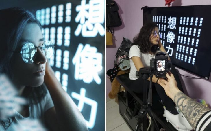 Chica sentada en un banquito negro, recargada en una pared decorada con letras en chino, fotografía creativa de Omahi
